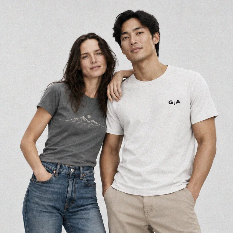 A woman in a charcoal graphic T-shirt and a man in a white graphic T-shirt standing side by side