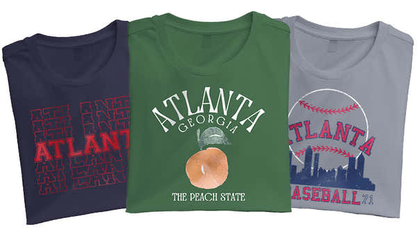 A collection of Atlanta-themed T-shirts in navy, green, and gray, featuring bold graphics celebrating the city and its baseball heritage.