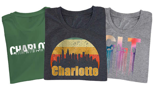 A selection of Charlotte-inspired t-shirts in green, dark gray, and light gray, each featuring different artistic representations of the city's skyline.