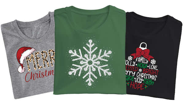 Three Christmas t-shirts; gray with 'Merry Christmas' in mixed prints, green with a white glitter snowflake, and black with 'FAMILY JOY LOVE MERRY CHRISTMAS HOPE' in a Christmas ornament shape.