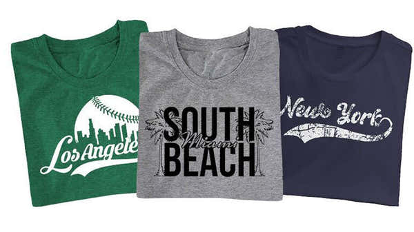 Banner featuring three city-themed t-shirts: green with 'Los Angeles' and a baseball design, gray with 'South Miami Beach' and palm trees, and navy with 'New York' in decorative script.