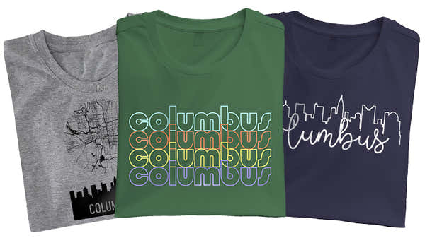 Three Columbus-themed t-shirts in gray, green, and navy, featuring unique city-inspired graphics.