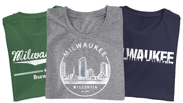 Three Milwaukee-themed t-shirts; green with 'Milwaukee Brew City' slogan, heather gray with skyline and 'Milwaukee Wisconsin', and navy with a bold 'MILWAUKEE' cutout design.