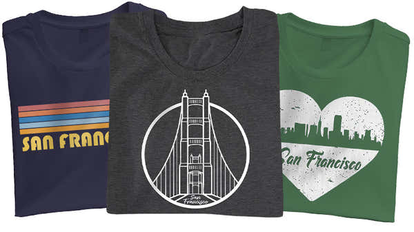 A display of three San Francisco-themed t-shirts: navy with a retro stripe and text, charcoal featuring a detailed Golden Gate Bridge graphic, and green with a heart-shaped city silhouette.