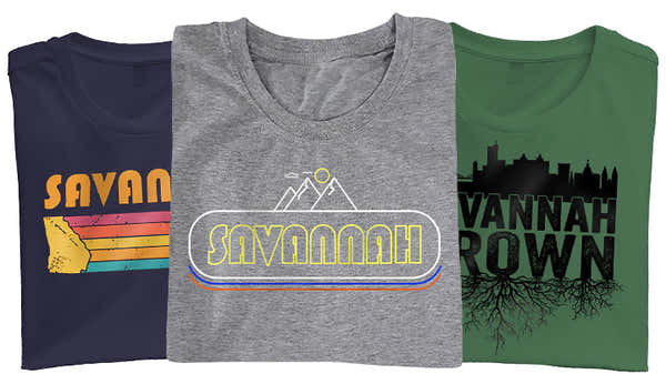 Banner featuring three t-shirts with Savannah themes: navy with retro stripes and 'Savannah', grey with a retro 'Savannah' logo, and green with 'Savannah Grown' and a city skyline silhouette.