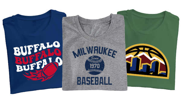 Three sports-themed t-shirts; a blue one with 'BUFFALO' repeated over a wing graphic, a heather gray with 'MILWAUKEE Baseball' and a vintage emblem, and a green one with a mountain and basketball logo.