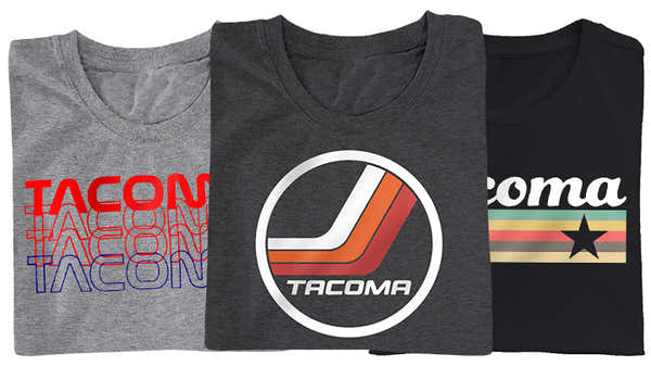 Banner showing three Tacoma-themed t-shirts: grey with layered 'TACOMA' text, black with the Tacoma logo in a modern circle, and grey with a retro Tacoma stripe design.